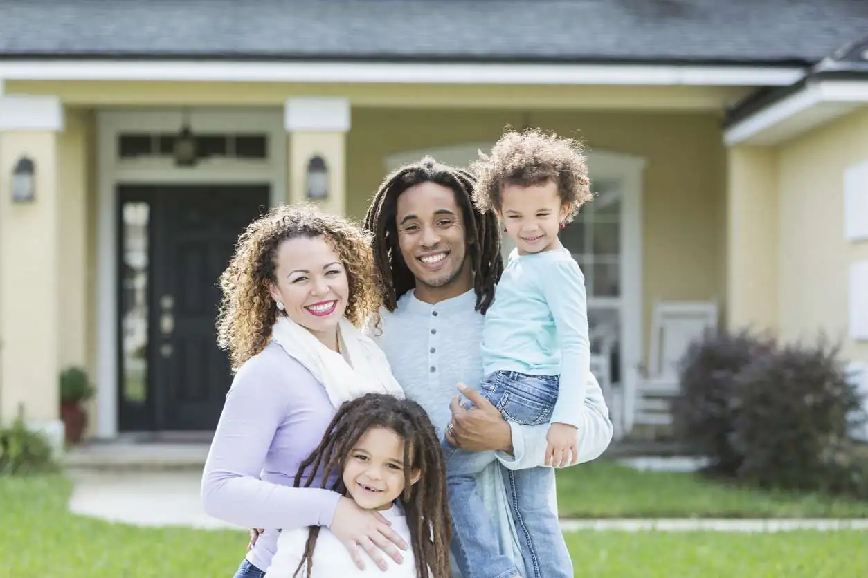 Mixed race family of four in front of home residential roof replacement family